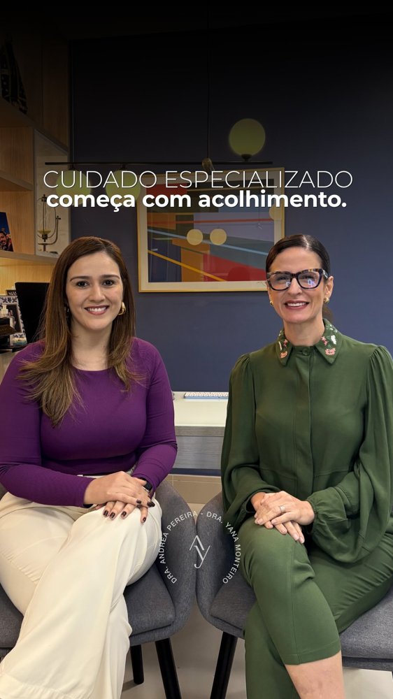 Recepção do consultório com parede azul-marinho, quadro colorido e poltronas, com a frase: cuidado especializado começa com acolhimento